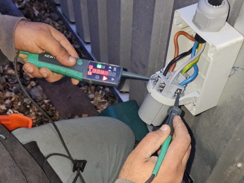Electrician from Handy Electric Pro carrying out electrical fault finding and testing on an outdoor electrical connection using professional testing equipment in Hounslow.
