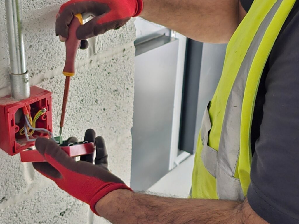 Electrician from Handy Electric Pro installing electrical wiring into a wall back box during a first-fix electrical installation